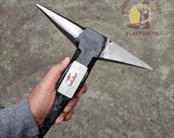 Peut inclure: Une enclume de forgeron en métal noir et argent avec une corne pointue. L'enclume porte une étiquette indiquant "Bharat Antique Shop Blacksmith".