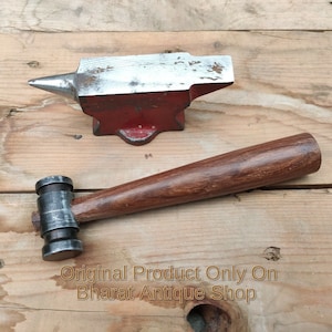 以下が含まれることがあります： 銀色のトップが付いた小さな赤い金属製の金床と、木製のハンドルと金属製のヘッドが付いたハンマー