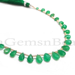 Può includere: Una collana di perle di pietra preziosa smeraldo verde a forma di pera, infilate su un filo d'oro con accenti di nappe verdi a ciascuna estremità. Le perle misurano circa 10 mm. La collana misura circa 45 cm di lunghezza.