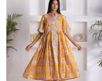 May include: A yellow floral dress with a pink and white floral print. The dress has a collared neckline, short sleeves, and a gathered skirt.