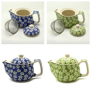 May include: Ceramic teapots with floral patterns in blue and green. Each teapot has a matching lid and a removable stainless steel infuser. The teapots are designed with a curved spout and a large handle.