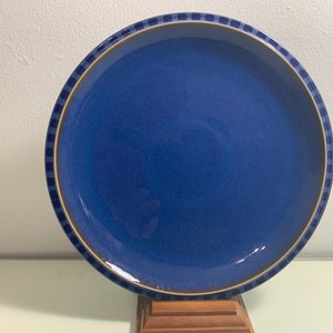 Puede incluir: Un plato de cerámica azul con un borde estampado en marrón y azul.
