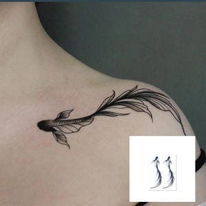 Może przedstawiać: Czarny i szary wzór tatuażu z rybą koi na ramieniu. Tatuaż przedstawia szczegółową rybę z płynącymi płetwami. Mały kwadrat pokazuje dwa podobne wzory tatuaży.