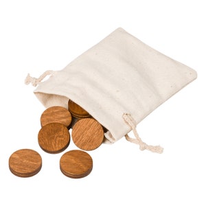 May include: A natural canvas drawstring bag with several wooden game pieces spilling out. The wooden pieces are circular and have a medium brown stain. The bag is off-white and has a simple design.