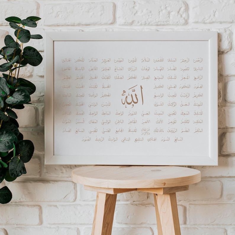 May include: A white framed print with a brown calligraphic design of the word "Allah" in Arabic script. The print features a list of 99 names of God in Arabic, known as the "Asma ul Husna".