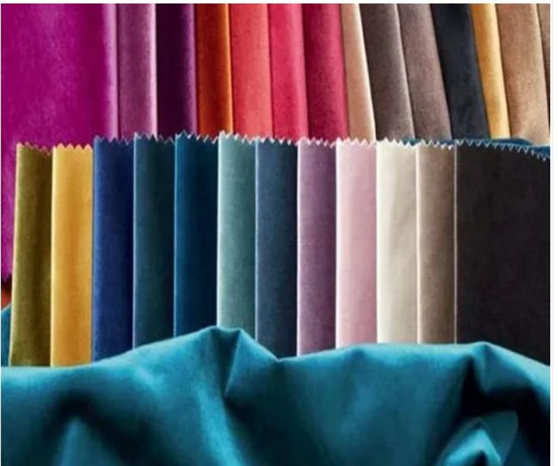 May include: A collection of colorful velvet fabric swatches in various shades, including teal, gold, blue, and pink. The swatches are arranged in a fan shape, showcasing the different colors and textures of the material. The image highlights the range of colors available.