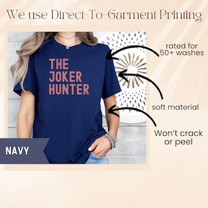 Pode incluir: Camiseta azul marinho com o texto "THE JOKER HUNTER" em marrom avermelhado. A camisa &eacute; feita de um material macio e &eacute; classificada para mais de 50 lavagens. A impress&atilde;o direta na roupa n&atilde;o racha nem descasca.