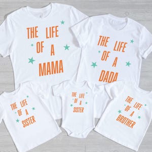 Pode incluir: Camisetas brancas e um body com texto laranja e estrelas turquesa. As camisetas dizem "THE LIFE OF A MAMA", "THE LIFE OF A DADA", "THE LIFE OF A SISTER" e "THE LIFE OF A BROTHER".