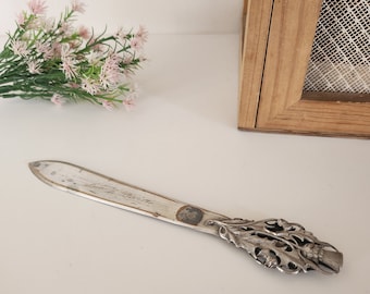 Vintage letter opener "souvenir of biville" in metal, plant decoration on the handle