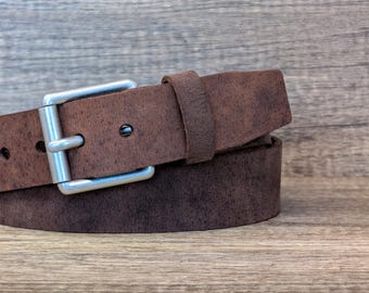 May include: A brown leather belt with a silver buckle. The belt is folded in half and the buckle is visible.