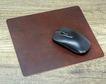 May include: A brown leather mouse pad with a black wireless mouse on top.