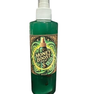 May include: A green spray bottle with a white cap and a label that reads "Money Boost Spray". The label features gold accents, dollar signs, and a glowing design. The bottle is filled with a green liquid.