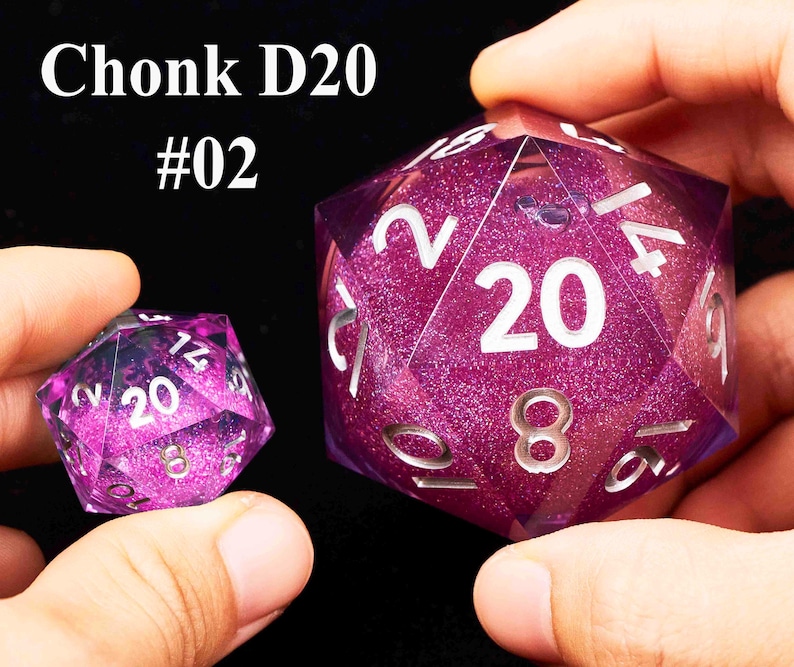 May include: Two purple D20 dice with glitter. The larger die has the number 20 on one side and the smaller die has the number 20 on one side. The larger die is labeled "Chonk D20 #02".