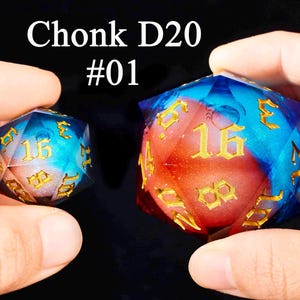 May include: Two multi-colored dice with gold numbers. The larger die is a twenty-sided die with a red and blue swirl pattern. The smaller die is a sixteen-sided die with a blue and white swirl pattern. Both dice have gold numbers and are labeled "Chonk D20 #01".