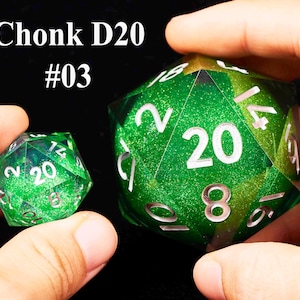 May include: Two green D20 dice with silver numbers. The larger die has a glittery finish and the smaller die has a smooth finish. The larger die has the number 20 on one side and the smaller die has the number 20 on one side. The text "Chonk D20 #03" is visible in the image.