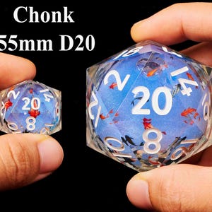 May include: Two blue and white D20 dice with gold fish designs. The larger die is 55mm and the smaller die is 20mm.