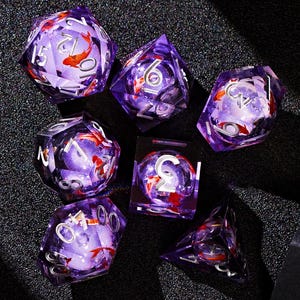 May include: Set of seven purple and clear dice with a koi fish design. The dice are numbered 1 through 6.