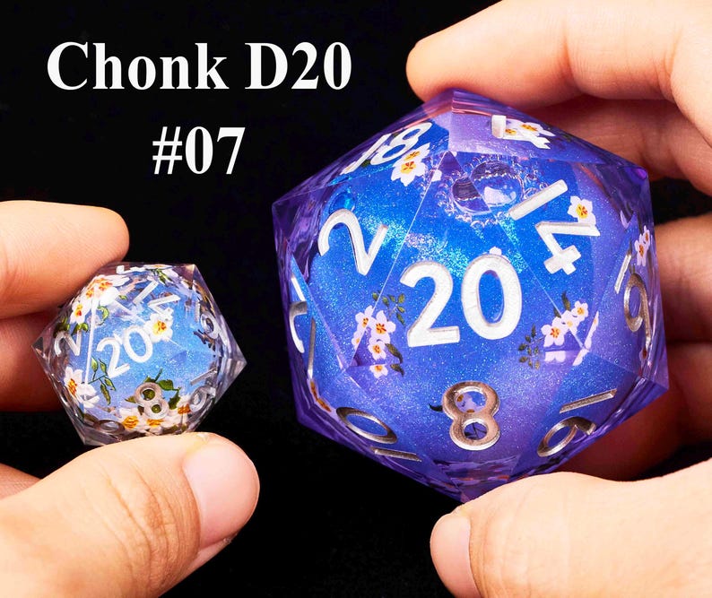 May include: Two purple and blue D20 dice with white numbers and floral designs. The larger die has the number 20 on the face and the smaller die has the number 20 on the face. The text "Chonk D20 #07" is in the top left corner of the image.