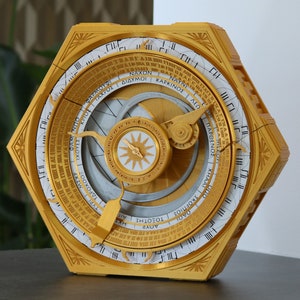 Può includere: Un orologio decorativo esagonale color oro con un quadrante bianco e segni neri. Il quadrante dell'orologio presenta testo greco e un quadrante rotatorio circolare color argento con una stella dorata al centro.