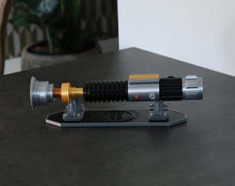 Empuñadura del sable de luz de Obi-Wan Kenobi - Réplica de accesorio de cosplay inspirado en la serie 'Obi-Wan Kenobi' - Incluye soporte con el logotipo Jedi