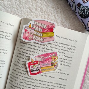 May include: A set of four pink and gold book-themed stickers with glitter accents. The stickers feature the text "Books Are My Love Language", "Sweethearts", "Triangle", and "Friends to Lovers". One sticker features a candle with hearts and flowers.
