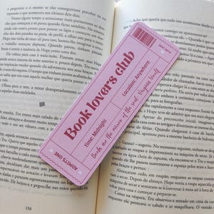 Op de afbeelding: Een roze bladwijzer met de tekst "Book Lovers Club" en de quote "Books are the mirror of the soul - Virginia Woolf." De bladwijzer ligt op een open boek.