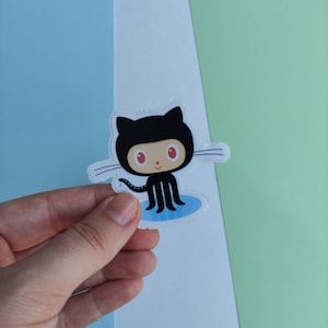 Peut inclure: Un autocollant de chat noir avec des yeux rouges et une flaque bleue en dessous. L'autocollant est sur un fond blanc.