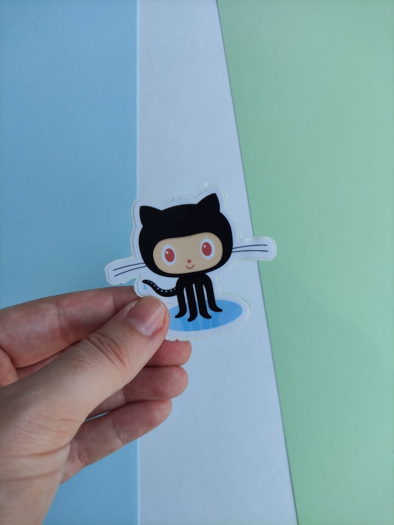 Peut inclure: Un autocollant de chat noir avec des yeux rouges et une flaque bleue en dessous. L'autocollant est sur un fond blanc.