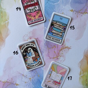 K&ouml;nnte beinhalten: Vier farbige Aufkleber mit einem Tarotkarten-Motiv. Die Aufkleber zeigen Illustrationen eines Geistes, der ein Buch liest, einer Hand, die ein Buch h&auml;lt, eines Stapels B&uuml;cher und eines ge&ouml;ffneten Buches mit einem Bleistift. Der Text auf den Aufklebern lautet "Quiet now. It's reading o'clock", "The Reader", "The Reader", und "The Annotator".