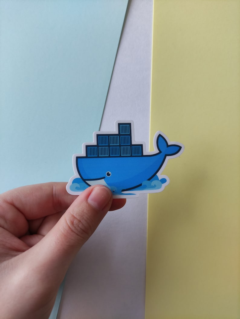 Peut inclure: Un autocollant de baleine bleue avec une pile de conteneurs sur son dos. La baleine nage dans une vague. L'autocollant est sur un fond bleu clair, blanc et jaune.