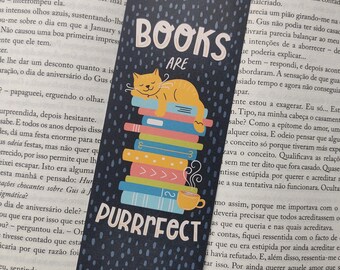 May include: A navy blue bookmark with the words "BOOKS ARE PURRRFECT" in white. A yellow cat is sleeping on a stack of colorful books. A yellow cup of coffee is next to the books. The bookmark is 15 cm long.