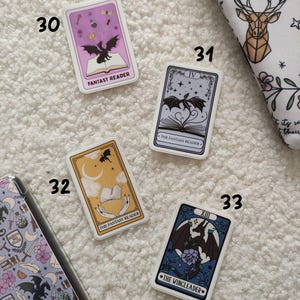 K&ouml;nnte beinhalten: Vier Aufkleber mit Illustrationen von Drachen und dem Text "The Fantasy Reader" und "The Wingleader".