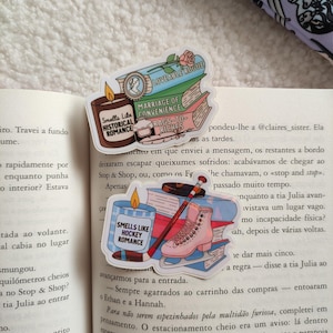 May include: Three colorful book-themed stickers with text that reads "Loveable Rogue", "Marriage of Convenience", and "Rags to Riches". The stickers also feature a rose, a candle, and a hockey stick with a pair of ice skates.