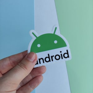 Peut inclure: Un autocollant repr&eacute;sentant un robot Android vert avec le mot "android" imprim&eacute; en noir en dessous.