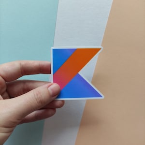 Peut inclure: Un autocollant repr&eacute;sentant le logo du langage de programmation Kotlin. Le logo est un K stylis&eacute; avec un d&eacute;grad&eacute; bleu, orange et rose.