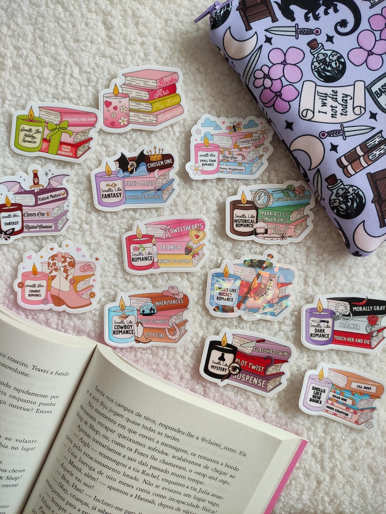 May include: A collection of colorful stickers featuring stacks of books with candles on top. The stickers have different titles and genres, including "Sweethearts", "Fantasy", "Cowboy Romance", "Historical Romance", "Morally Gray", "Plot Twist", and "Chosen One".