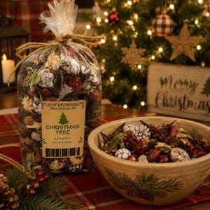 May include: A clear plastic bag filled with Christmas tree scented potpourri, tied with twine, featuring a label that reads JUST BROWSING New Oxford, PA CHRISTMAS TREE SCENTED POTPOURRI, alongside a beige ceramic bowl containing the same potpourri.