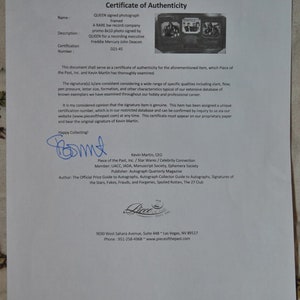 May include: A black and white framed photograph of the band Queen signed by Freddie Mercury and John Deacon. The certificate of authenticity is from Piece of the Past, Inc. and is signed by Kevin Martin, CEO.