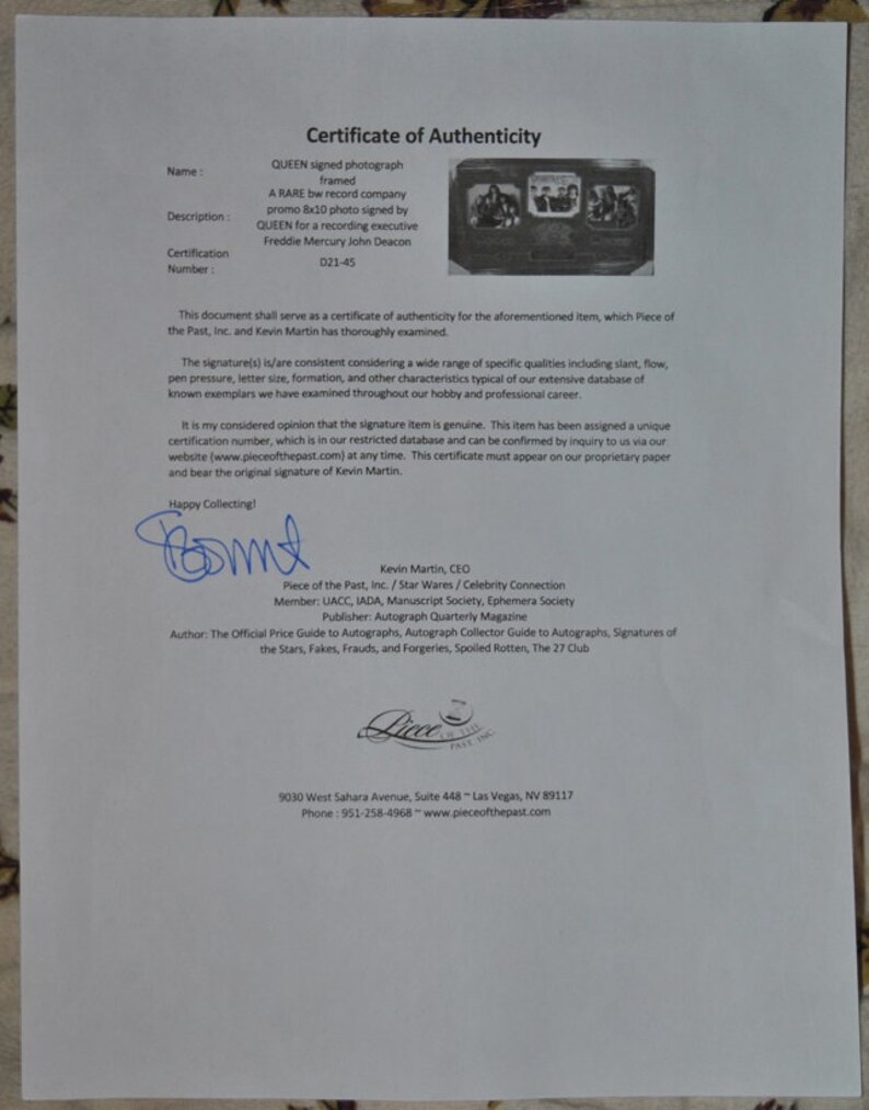 May include: A black and white framed photograph of the band Queen signed by Freddie Mercury and John Deacon. The certificate of authenticity is from Piece of the Past, Inc. and is signed by Kevin Martin, CEO.