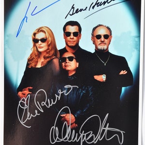 Może przedstawiać: Czarno-białe zdjęcie czterech osób, wszystkie w okularach przeciwsłonecznych i czarnych ubraniach. Zdjęcie jest podpisane przez wszystkie cztery osoby, w tym Gene'a Hackmana, Aleca Baldwina, Rene Russo i Dennisa Quaida.