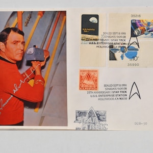 May include: A color photograph of William Shatner, the actor who played Captain Kirk in the original Star Trek television series, holding a prop from the show. The photo is signed by Shatner. The photo is part of a commemorative envelope with a Star Trek stamp and a Star Trek logo.