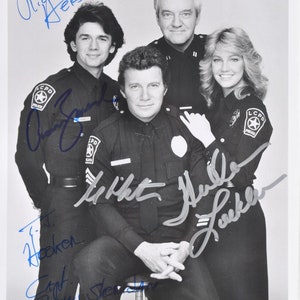 Puede incluir: Foto en blanco y negro de cuatro actores con uniformes de policía. Los actores sonríen y miran a la cámara. La foto está firmada por cada uno de los actores:  "Richard Herd", "Danny  "J.  Hooker", "Whit  "Whit"  Muller", y "Michelle  "Michelle"  Lee"
