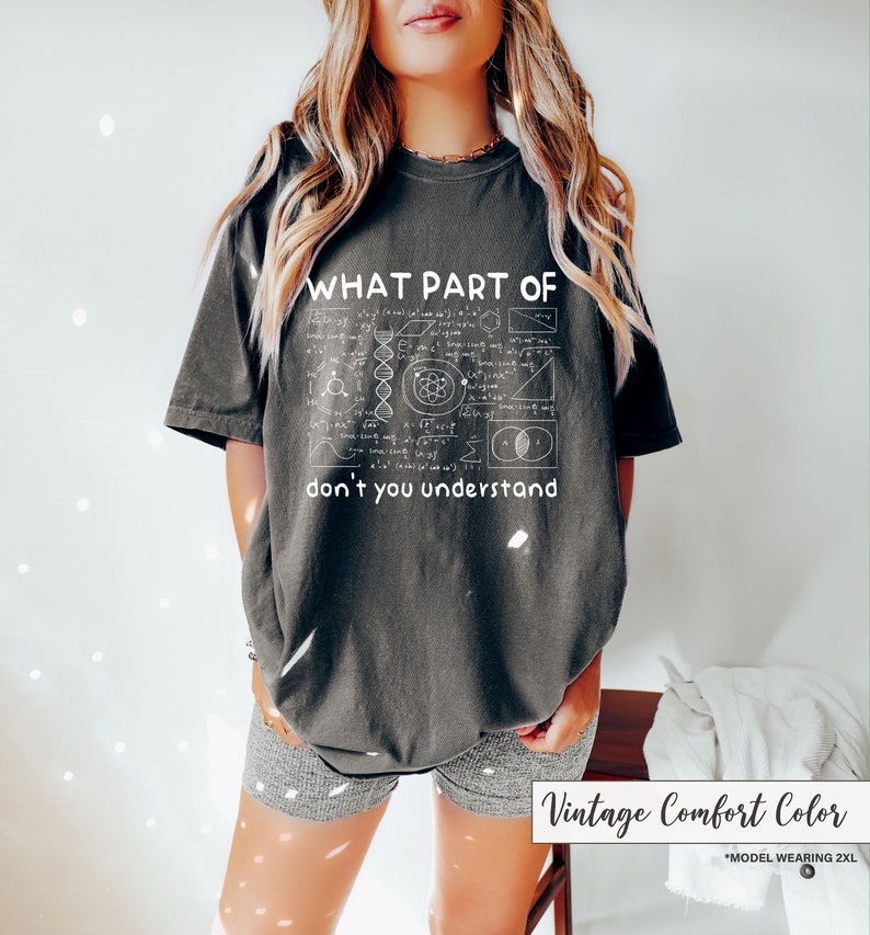 May include: Dark gray t-shirt with the text "WHAT PART OF don't you understand" and a white graphic of mathematical equations and diagrams. The shirt is a vintage comfort color.