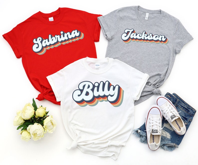May include: Three t-shirts with retro-style names printed on them. The shirts are red, white, and grey. The names are Sabrina, Billy, and Jackson.