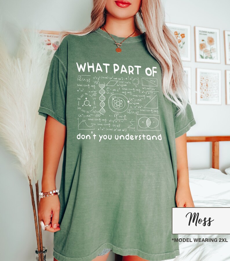 May include: Moss green t-shirt with the text "WHAT PART OF don't you understand" in white. The shirt features a graphic of mathematical and scientific symbols. The model is wearing a 2XL size.
