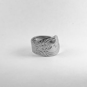May include: A silver ring made from a recycled spoon with a floral design.