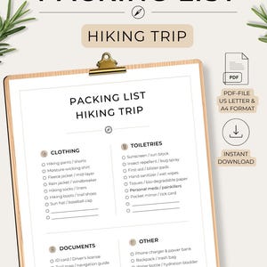 Könnte beinhalten: Eine digitale Packliste für eine Wanderung auf einem Klemmbrett. Das Dokument enthält Abschnitte für Kleidung, Toilettenartikel, Dokumente und Sonstiges mit Kontrollkästchen. Text beinhaltet "PACKING LIST", "HIKING TRIP", "PDF-FILE US LETTER & A4 FORMAT".