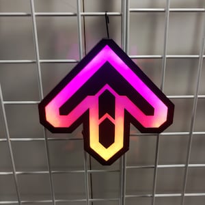 May include: A black and white geometric arrow-shaped light with a pink and orange gradient glow. The light is hanging from a white wire grid.