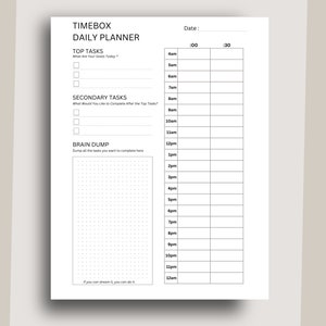 May include: A black and white daily planner with the title "TIMEBOX DAILY PLANNER". The planner has sections for "Top Tasks", "Secondary Tasks", and "Brain Dump". There is a time grid from 4am to 12am with columns for :00 and :30.