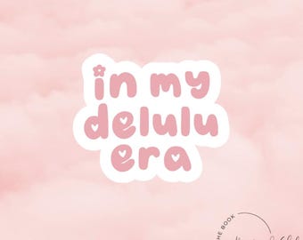 May include: Pink and white sticker with the text "in my delulu era" with a small flower and hearts. The sticker is on a pink background with a white circle with the text "The Boyfriend Club Est. 2022" in black.